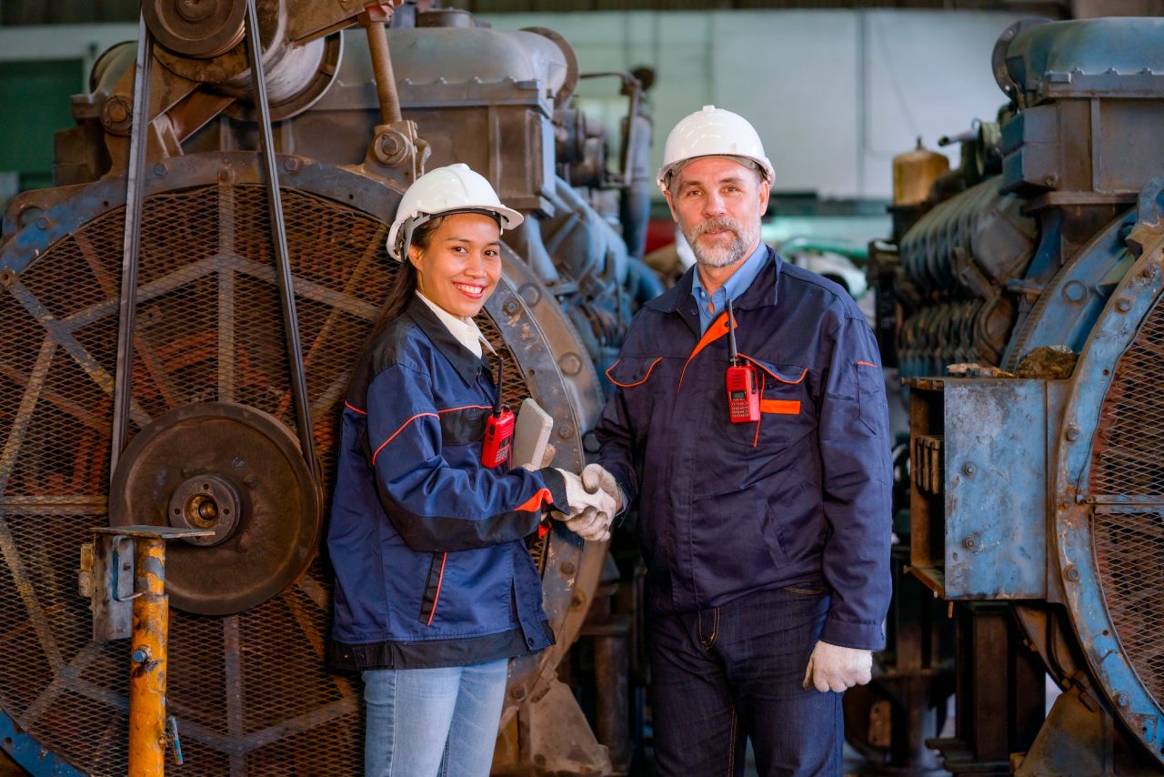 factory-worker-or-technician-stand-and-shake-hands-with-asian-factory-woman-in-front-of-big-machine.jpg